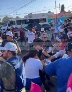 Tres morenistas golpean a una joven en el suelo, mientras que compañeros tratan de rescatarla